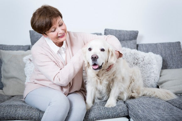 woman sitting on sofa with her dog