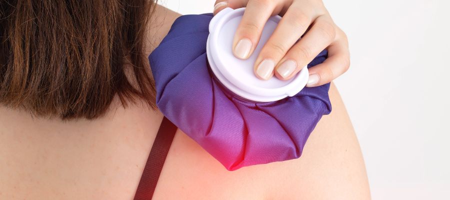 Woman cooling shoulder with an ice pack for arthritis flares