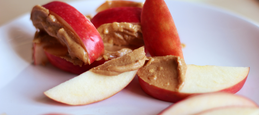 red apples sliced up into pieces with peanut butter on top