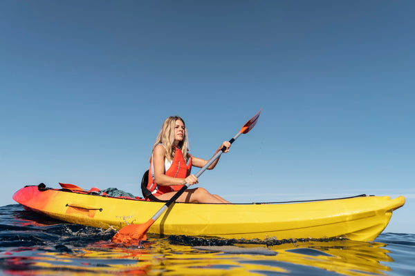 a woman kayaking at the water