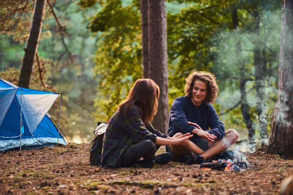 two people camping in the forest