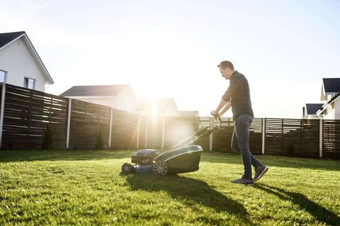 A man mowing the lawn with the push lawn mower