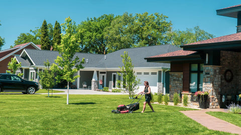 a woman mowing her lawn with her push lawn mower