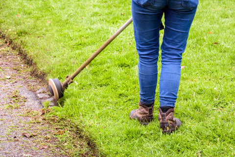 A woman edging the lawn with the lawn edger