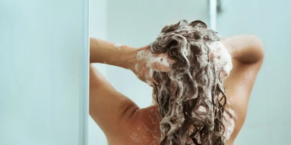 La donna si lava i capelli con shampoo senza silicone