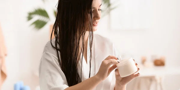 De vrouw gebruikt conditioner voor haar haar