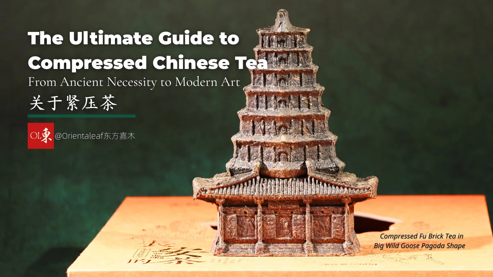 Compressed Chinese tea brick shaped like a miniature pagoda (Big Wild Goose Pagoda shape), resting on an orange box.