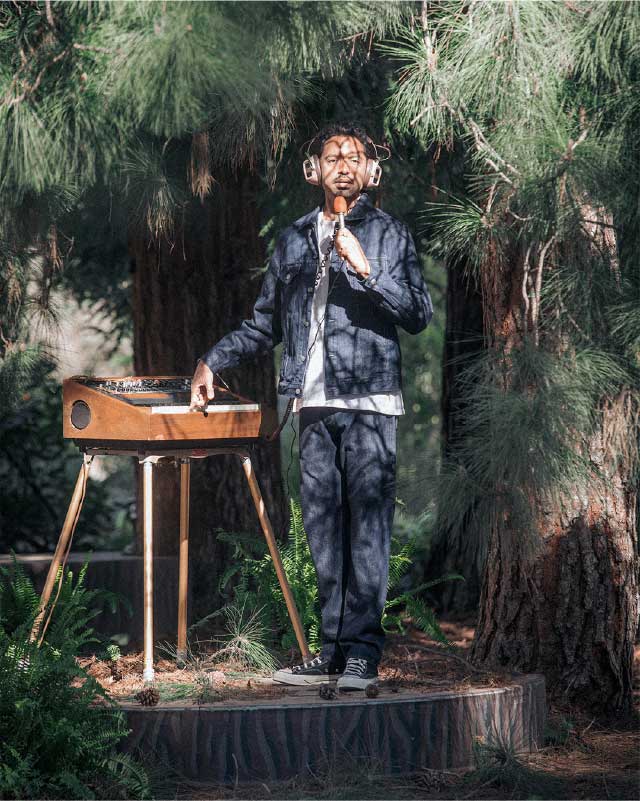 A man who styled in Levi's Wellthread collections is testing his microphone in the forest - Levi's Hong Kong