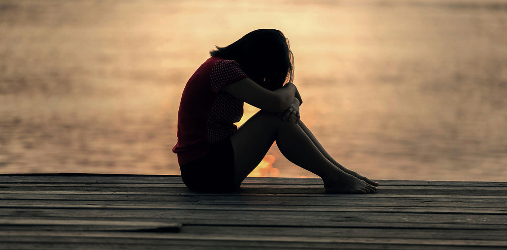 girl sitting afraid on a deck