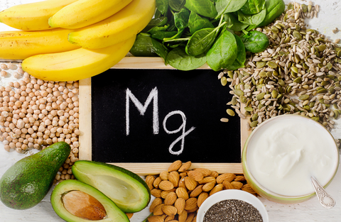 Magnesium rich foods around a chalkboard with mg written on it