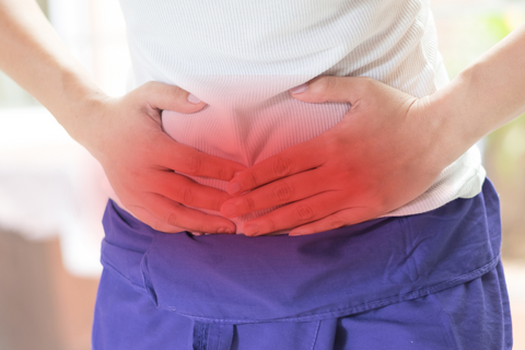 Person holding stomach from gall bladder pain