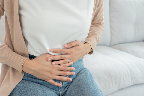 Woman holding stomach from constipation