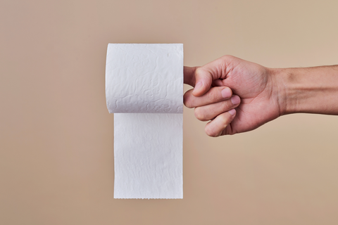 Person holding roll or toilet paper with two fingers