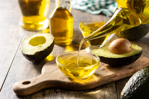 Avocado oil pouring in a clear bowl for hair growth