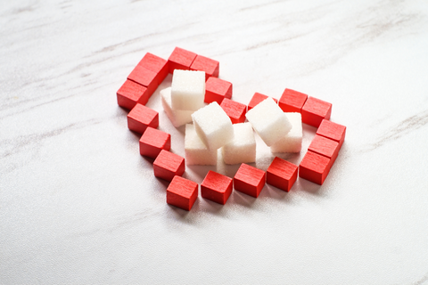 Red heart made of blocks around white sugar cubes