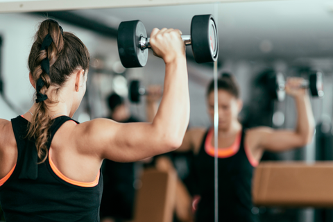 Woman with braided hair lifting weights