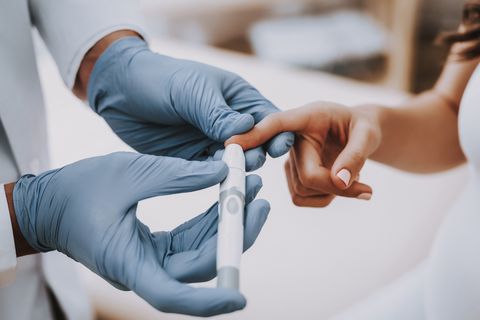 Person with diabetes pricking finger to check blood sugar