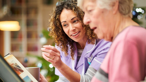 care nurse reading to senior woman with dementia