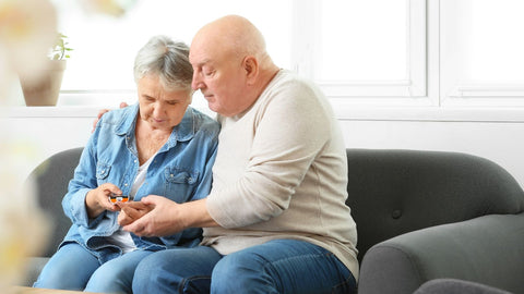older couple monitoring diabetes on couch