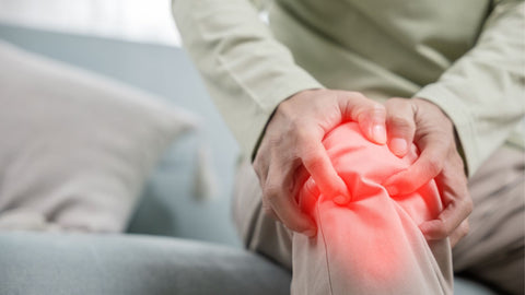 Person with osteoarthritis pain holding knee