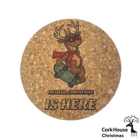 A cork coaster with a printed cartoon reindeer and text reading "Oh Deer Christmas is Here"