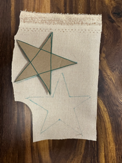 A cardboard cut out of a star on the back of cork fabric.