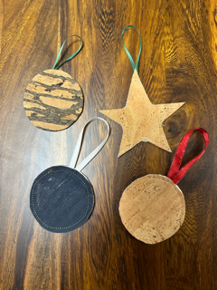 three cork ball puff ornaments and one star puff ornament on a wood table