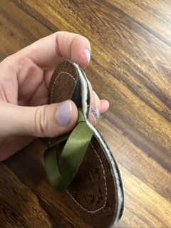 The edge of a cork fabric ornament pulled to one side so it can be trimmed without cutting the ribbon loop for hanging.