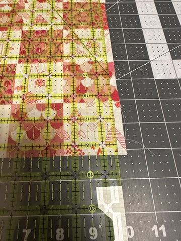 Close up view of the fabric made from 2.5in squares being trimmed to size