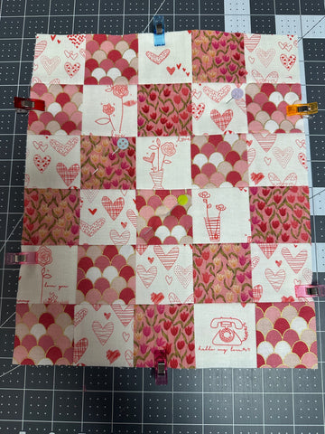 The quilt sandwich pinned in the middle and wonder clips holding the edges together.