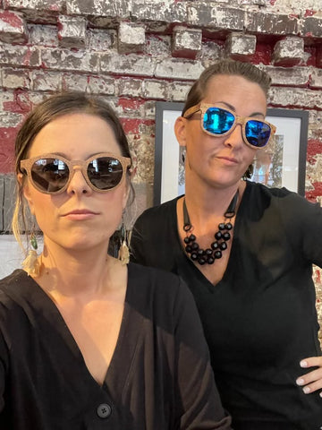 Two women wearing black posing with cork sunjay sunglases