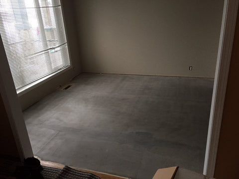 Multipurpose room with subfloor installed, covered in a leveling compound, and free of dirt or scraps