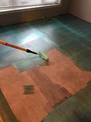 Contact cement being rolled onto the subfloor prior to installation