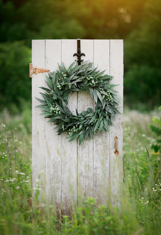 Bayleaf farmhouse wreath on white front door in sunny field