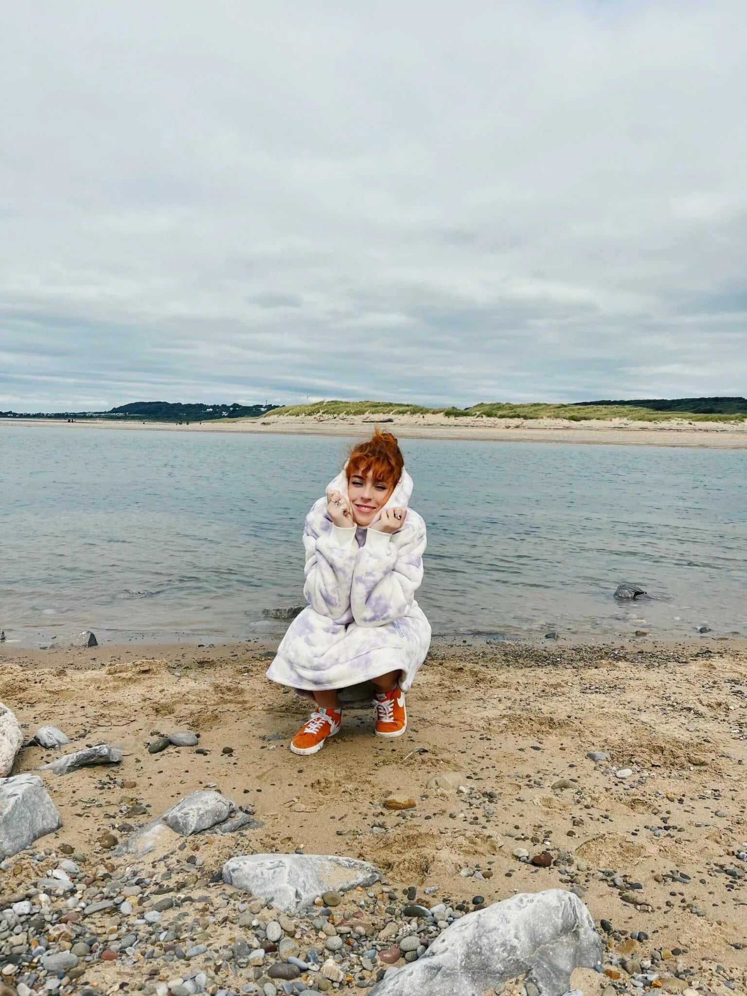 Woman wearing hoodie blanket at the beach