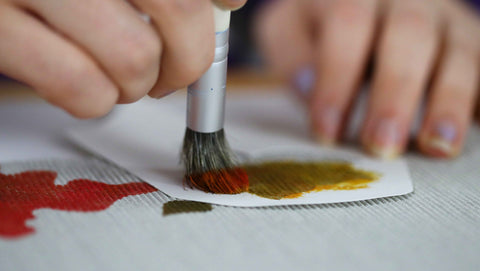 Dabbing paint onto a leaf stencil