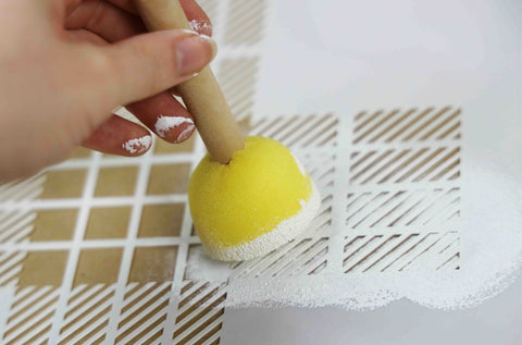 Using a sponge brush and stencil to make wrapping paper