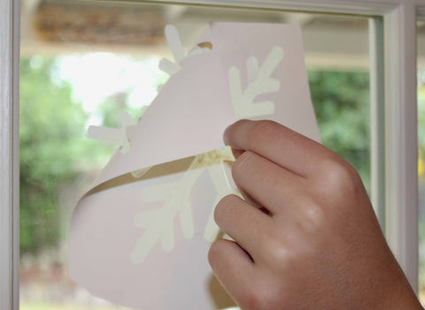 Peeling an adhesive stencil away from a window