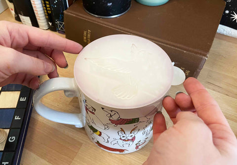 Placing a coffee stencil onto a mug