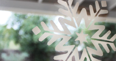 Plantilla de copo de nieve pintada en una ventana con un bolígrafo acrílico
