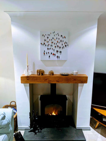 Square wall art looks great over the fireplace in a light and modern room.