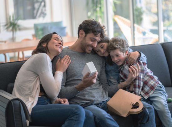 Candid shot of a loving family with dad holding a present