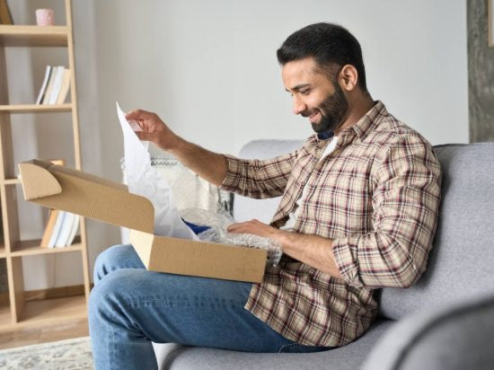 Man opening up kick ass gift on on couch