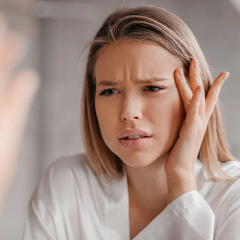 une femme avec un visage inquiet se regardant dans un miroir