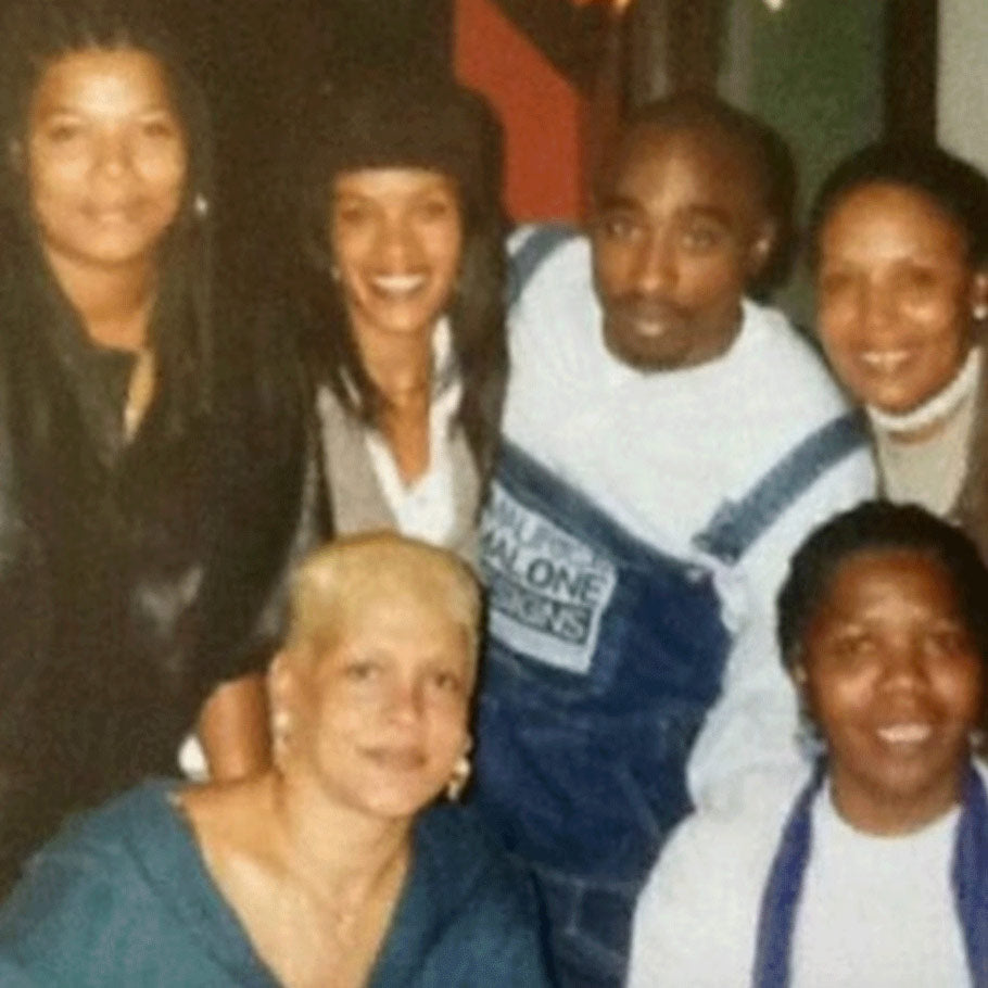 90s photo of Tupac wearing Maurice Malone back pack denim overalls. The photo also features Queen Latifah and other women in hip-hop culture.