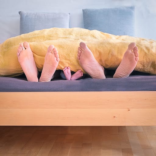 family barefoot in bed