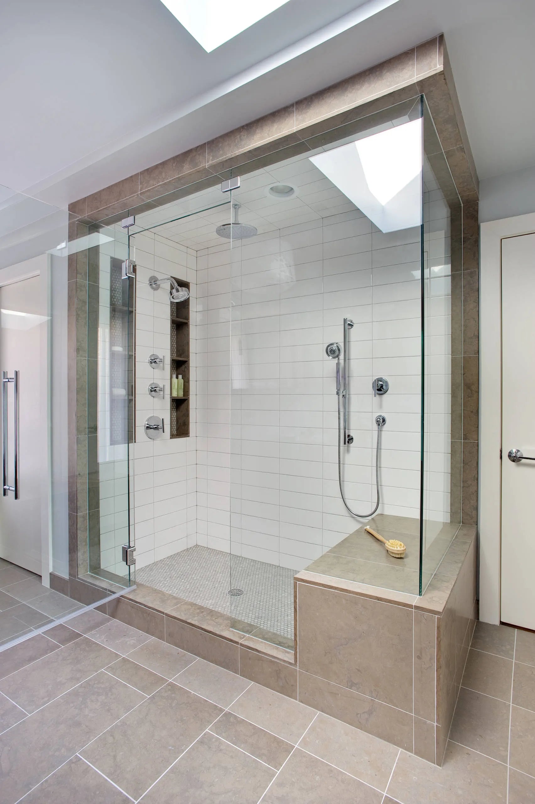 Modern 3-way shower system with rain/handheld sprays, white subway tile, and built-in wooden bench in minimalist bathroom.