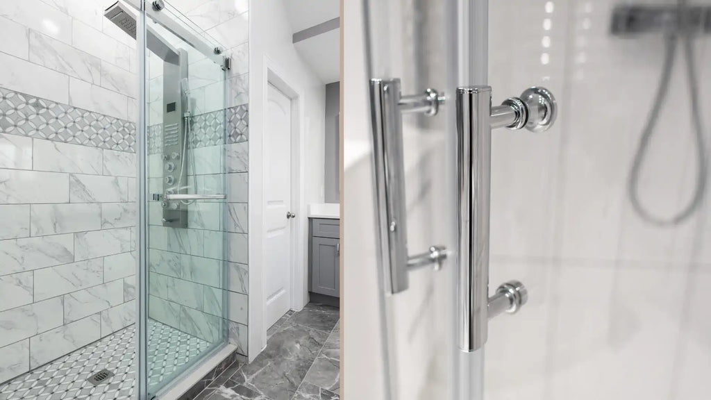 Close-up of sleek chrome frameless glass shower enclosure hardware on a glass door in a modern bathroom with marble tiles and grey vanity.