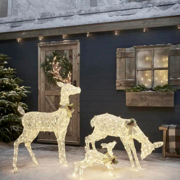 Sparkling reindeer christmas light decorations in a snowy garden for festive outdoor decor.