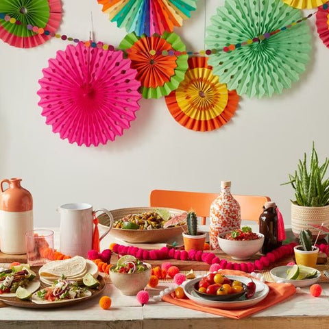 Vibrant 'Around the World' party setup with international cuisine for an adult birthday.